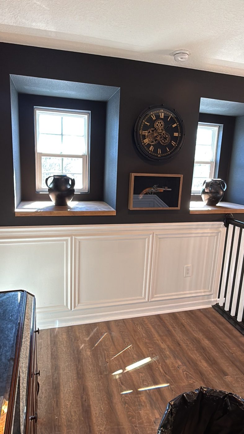 Loft with charcoal walls, deep window niches with wood sills and white wainscoting