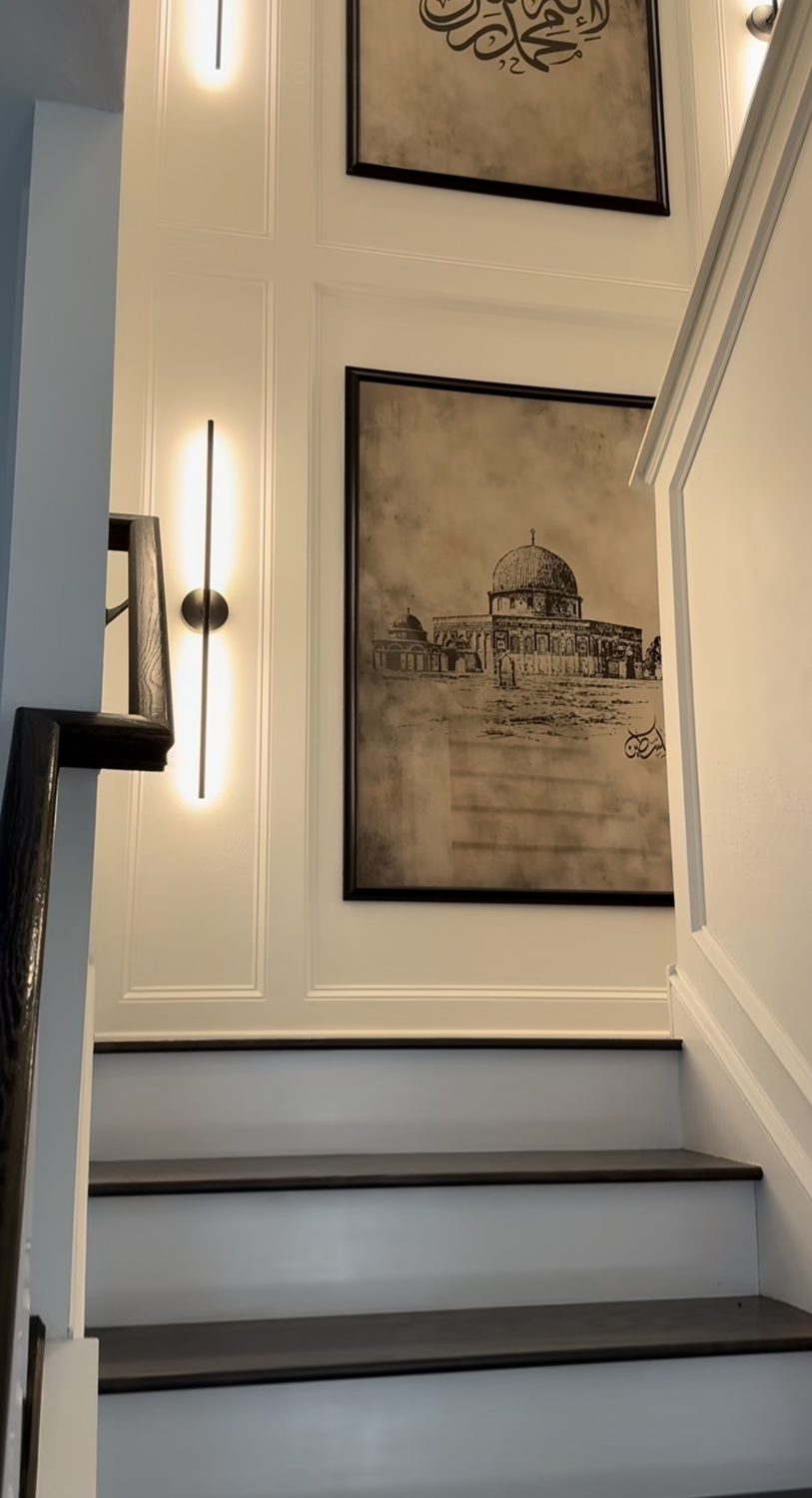 Staircase wall with moulding panels and linear wall lights