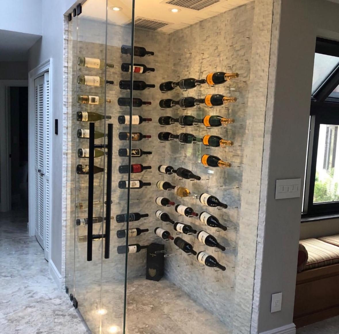 Glass-enclosed wine wall with stacked stone and floating bottle racks